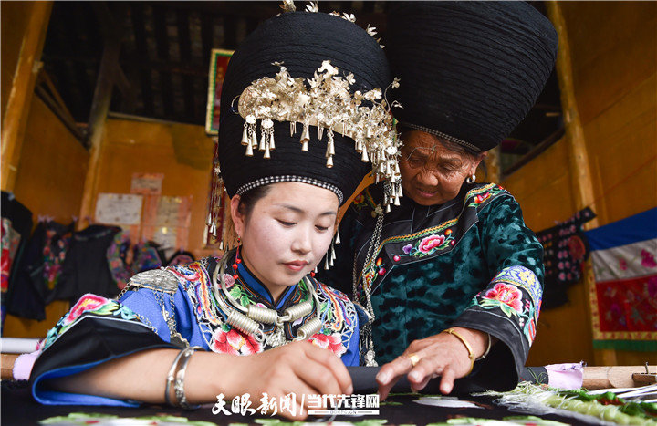 在貴州省銅仁市松桃苗族自治縣太平營(yíng)街道老寨村，一老人在指導(dǎo)繡娘繡苗繡。.jpg